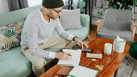 Young man at home sorting out his finances