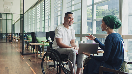 Student in a wheelchair talking to another student