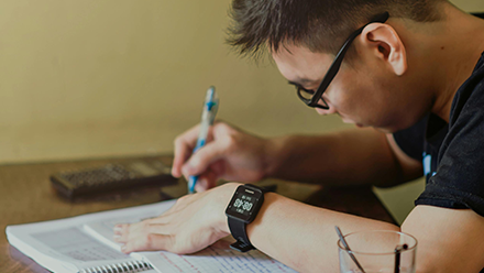 Man in black shirt sitting and writing