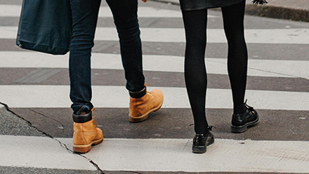 Two people walking on a zebra crossing