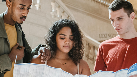 Three students looking at a map