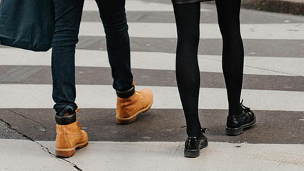 Two people walking on a zebra crossing