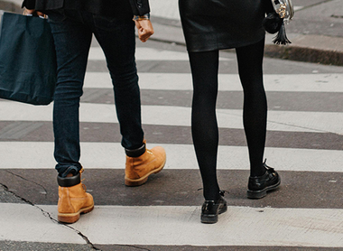 Two people walking on a zebra crossing