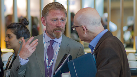 Two men talking at a conference