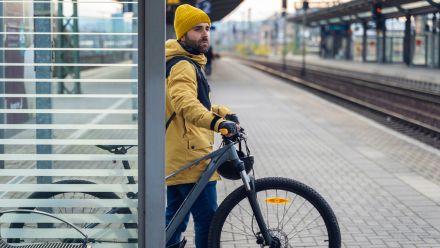 Man holding his bike on a train platform