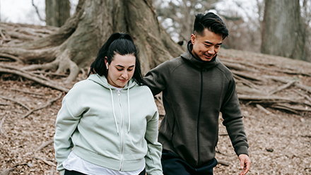 Young Asian trainer and woman walking in autumn