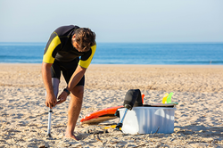 Man in a wetsuit corrects his prosthetic leg