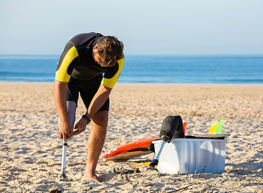 Man in a wetsuit corrects his prosthetic leg